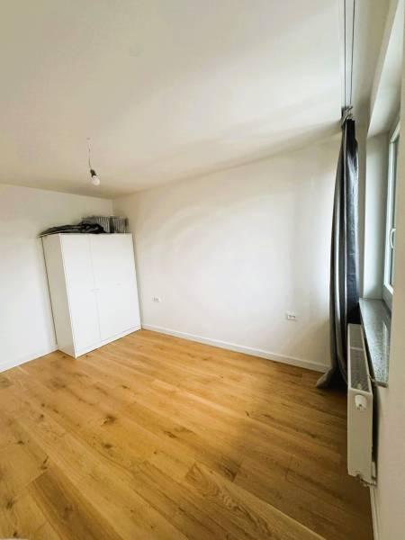 A room in a family house with a white wardrobe and a wooden decor floor.