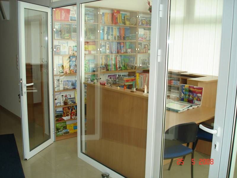 Glazed commercial spaces with books and brochures behind a wooden counter.