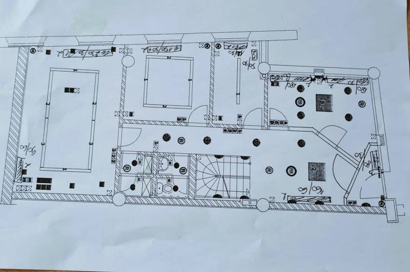 Floor plan of commercial spaces with bathrooms and staircase, including the labeling of electrical devices.