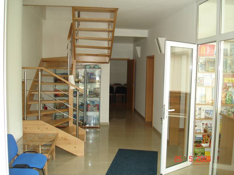 Interior of commercial premises with a wooden staircase and a glass display cabinet.