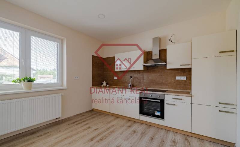 A kitchen in a family house with a wooden floor decor and a large window by the radiator.