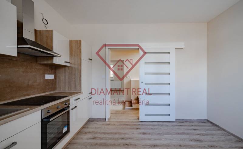 A kitchen in a family house with wooden decor, white built-in wardrobe, sliding doors.