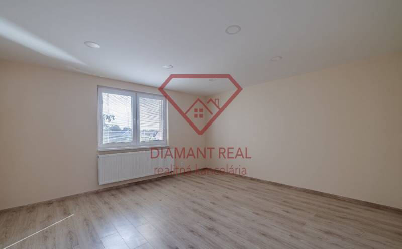 A room with a wooden floor design and a large window in a family house.