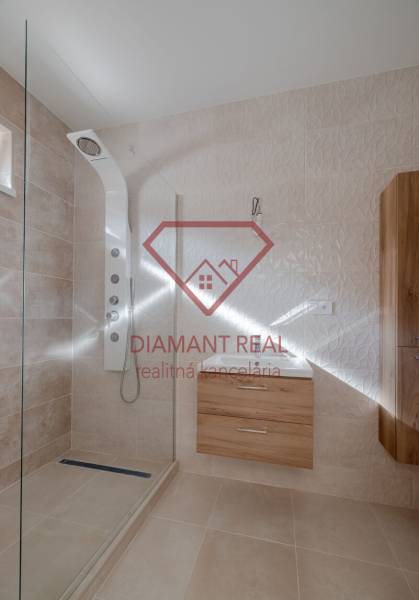 Bathroom with a shower and furniture with wood decor in a family house.