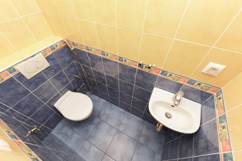 Bathroom in a family house with tiles and a toilet.