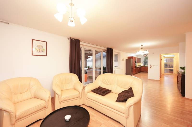 Living room of a family house with a cream sofa and a wooden decor floor.