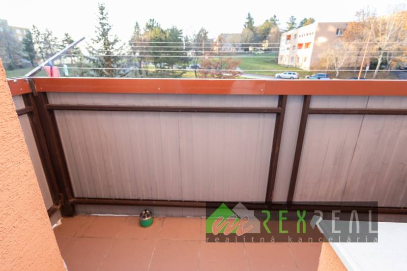 A balcony with a view of greenery from a 4-room apartment in the town of Veľký Krtíš on Hviezdoslavova Street.