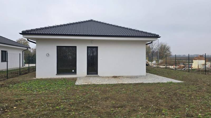 A family house in Cífer with a white facade and a terrace in the garden.