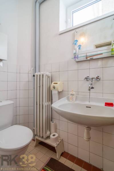 A bathroom in a family house with a sink, toilet, and bathroom accessories.