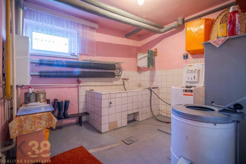 Laundry room in a family house with a washing machine, dryer, and storage space.