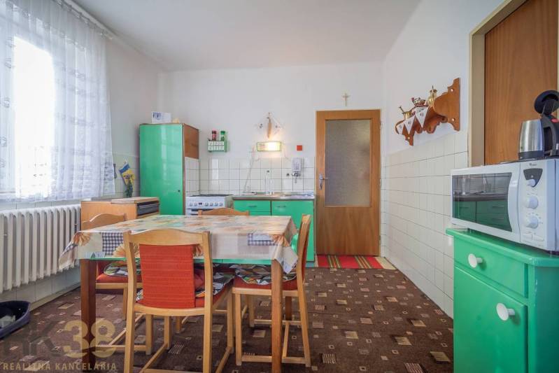 A kitchen in a family house with retro furniture, a dining table, and kitchen equipment.