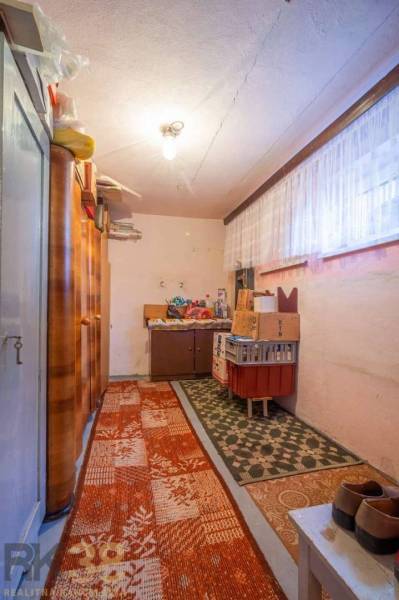 Storage space in a family house with carpets, shelves, and boxes.