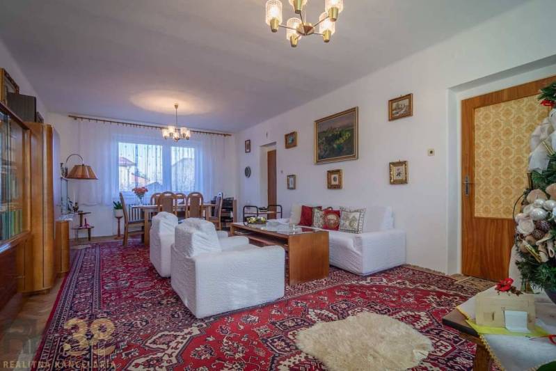 Living room in a family house with a carpet, sofas, and a table sufficient for comfortable relaxation.