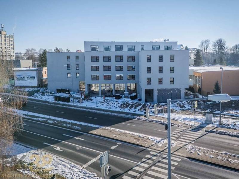 A building in the city of Poprad with a snowy surrounding and an intersection in the foreground.