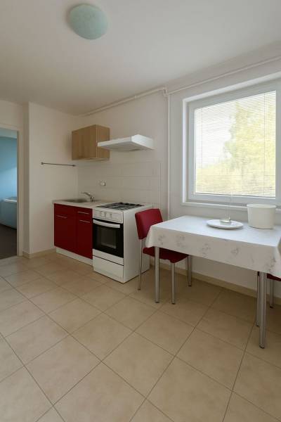 A kitchen with a red cabinet, a table, and two chairs in a family house.