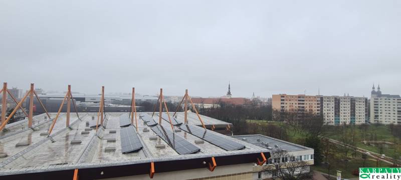 A view of Spartakovská Street in Trnava with buildings and solar panels on the roof.