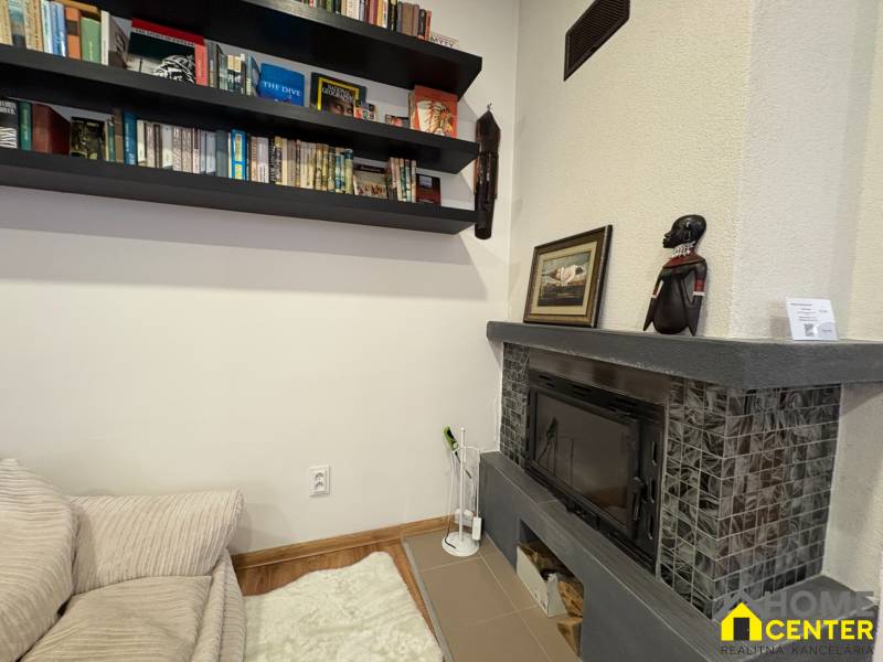 Library and fireplace in a cozy studio apartment with decorative African motif.