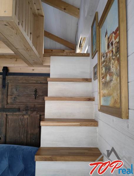Wooden stairs in a family house, walls with hanging pictures.