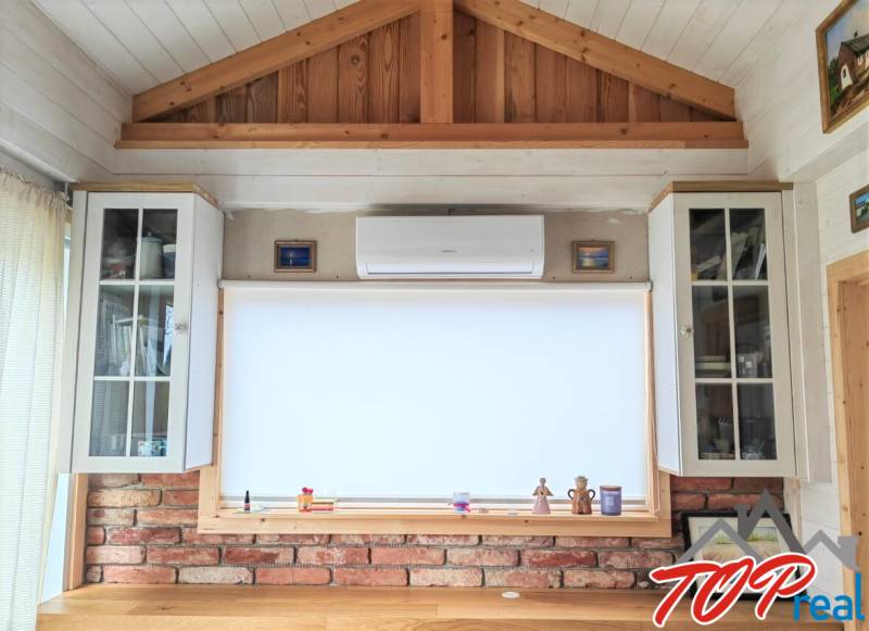Interior of a family house with air conditioning, a brick wall, and a wooden decor floor.