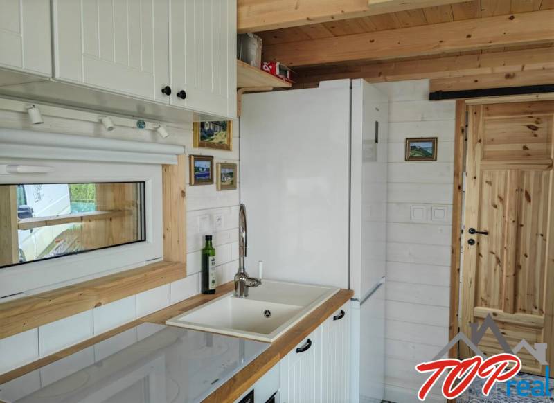 A kitchen in a family house with white furniture and wooden elements.