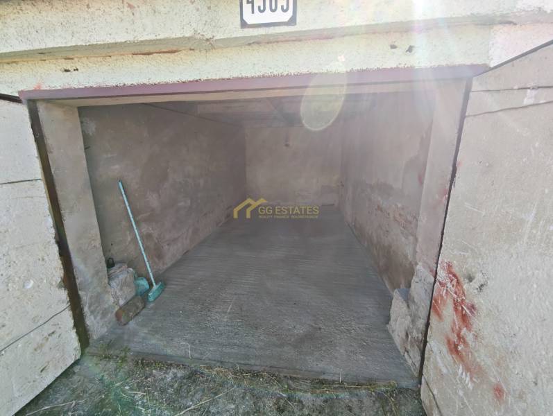Garages on Okružná Street in Michalovce with concrete flooring and a broom.