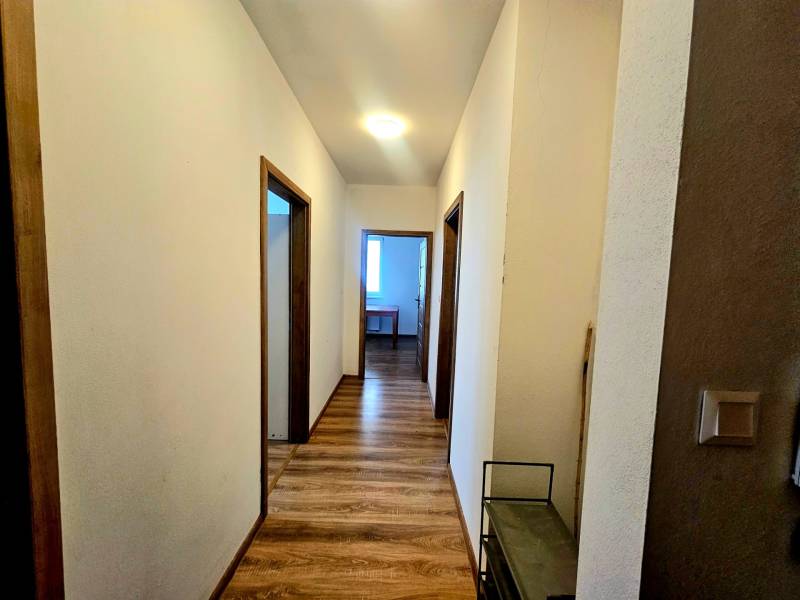 A hallway with a wooden decor floor in a 2-room apartment.