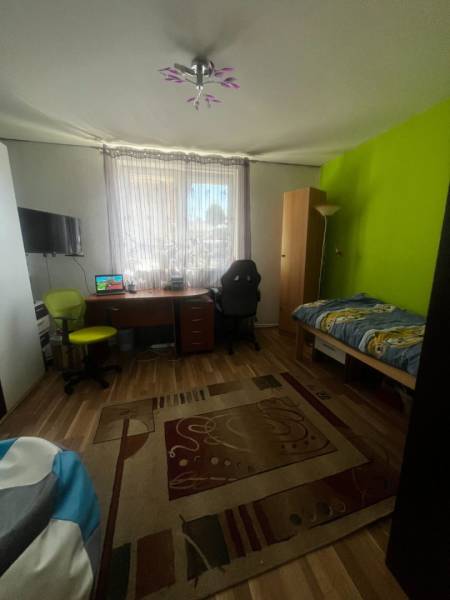 Children's room in a family house with a colorful wall, a desk, and a floor with a wooden decor.
