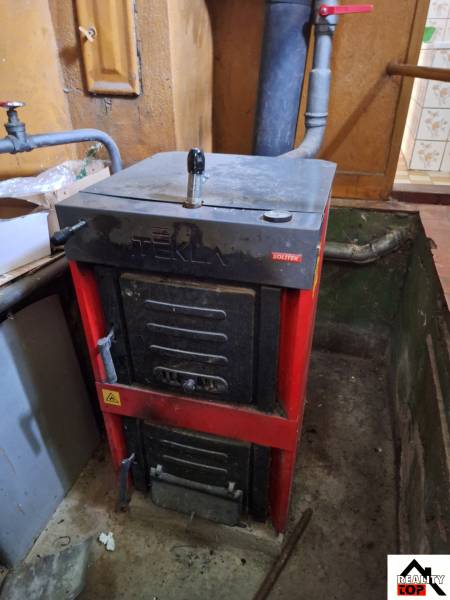 Solid fuel furnace in the basement of a family house, with a connected flue for exhaust gases.