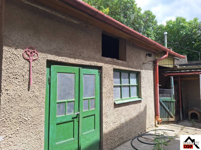 A family house in Tachtoch with two green doors and a light-colored facade.