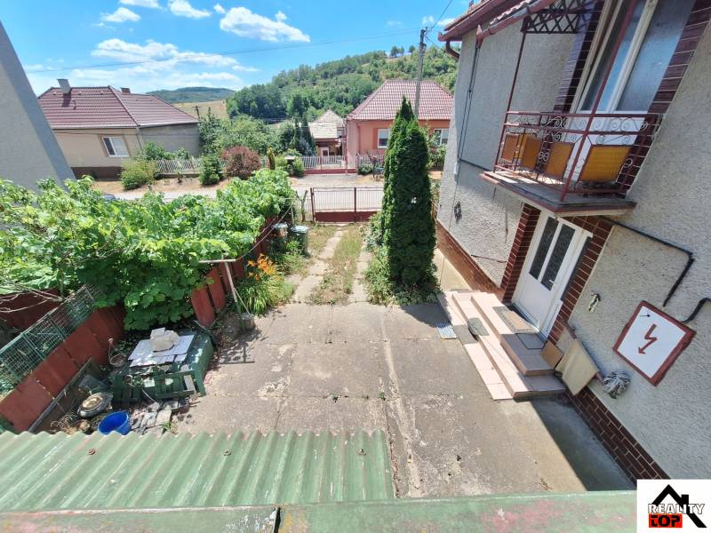The exterior of a family house in Tachta with a small garden and a view of the hills.