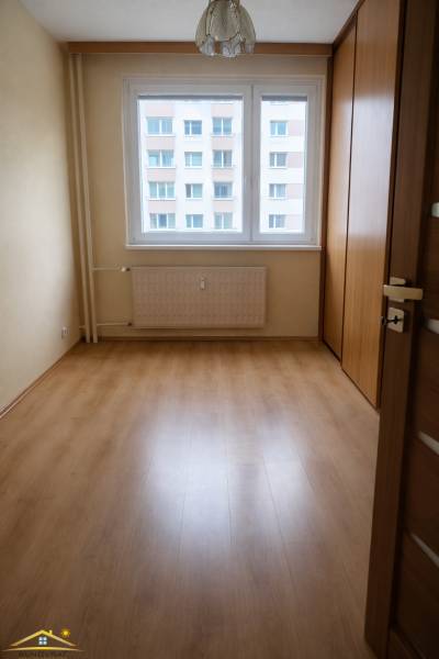 A room with a wooden floor decor and a large window in a 3-room apartment.