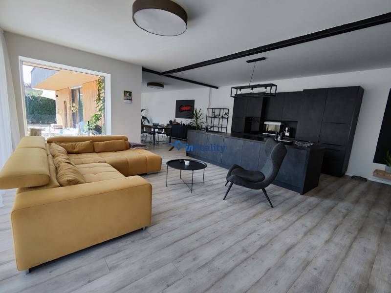 Living room in a family house with a wood-patterned floor and a comfortable sofa.