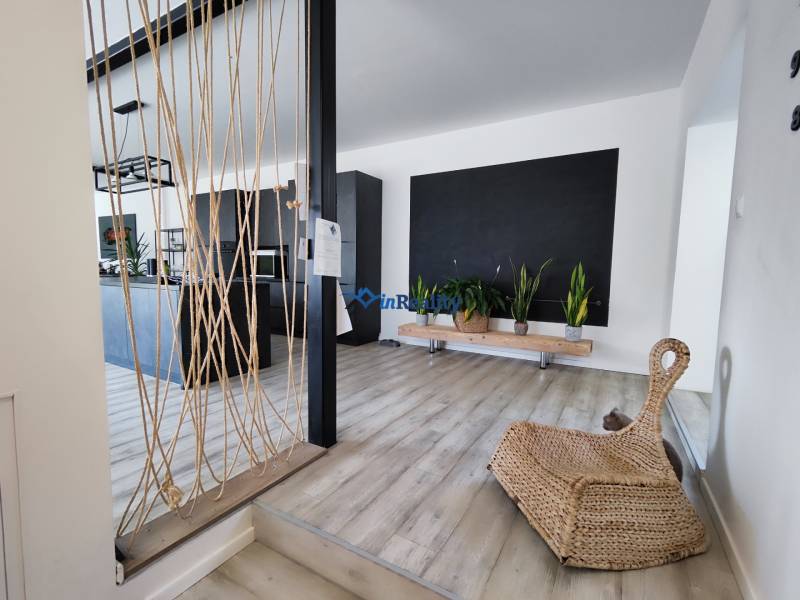 Interior of a family house with a wooden decor floor, plants, and rope decoration.