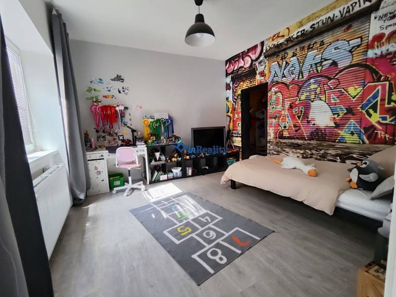 Children's room in a family house with graffiti on the wall and a floor with a wooden decor.