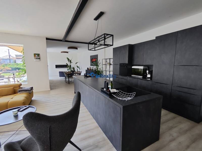 Living room connected with the kitchen in a family house with a wooden decor floor.