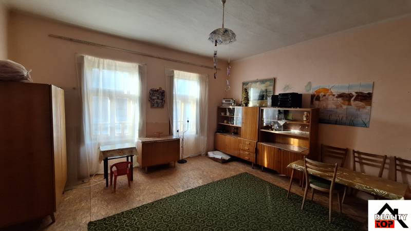Living room of a family house with wooden furniture, carpet, and table.