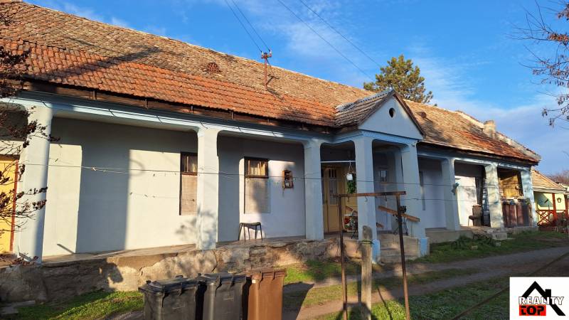 A family house in Rapovce with traditional architecture, a veranda, and a shingle roof.