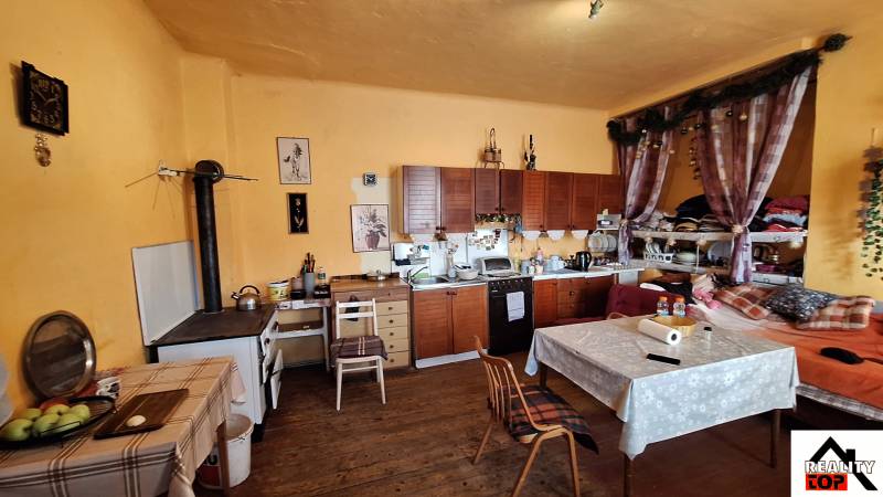 A kitchen with wooden decor, rustic cabinets, and decorations in a family house.