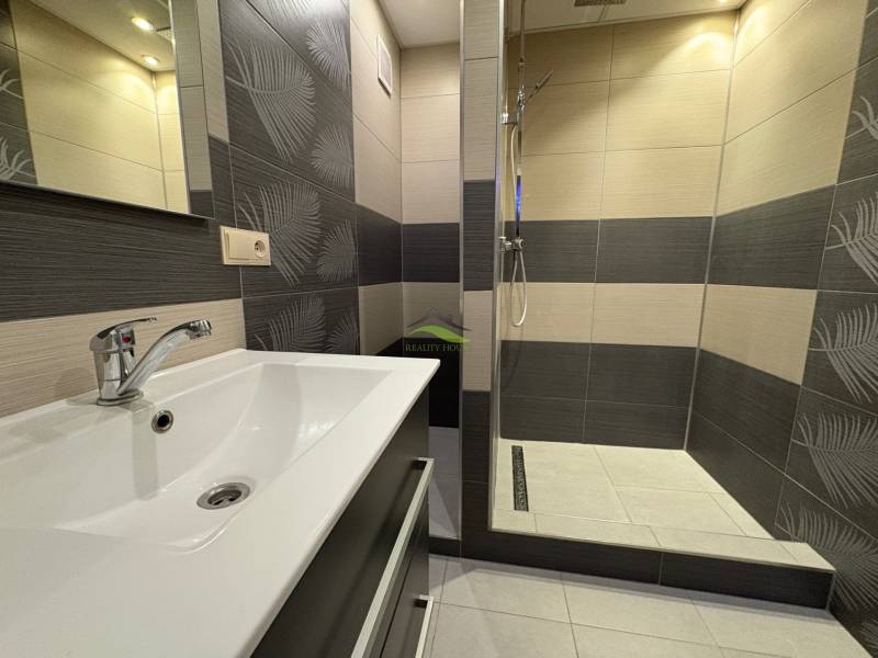 A bathroom in a 3-room apartment with modern tiles and a shower corner.