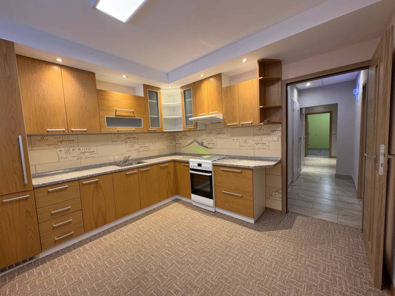 A kitchen in a 3-room apartment with wooden decor and built-in appliances.