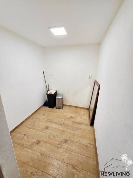A small room in a one-bedroom apartment with a wooden decor floor.