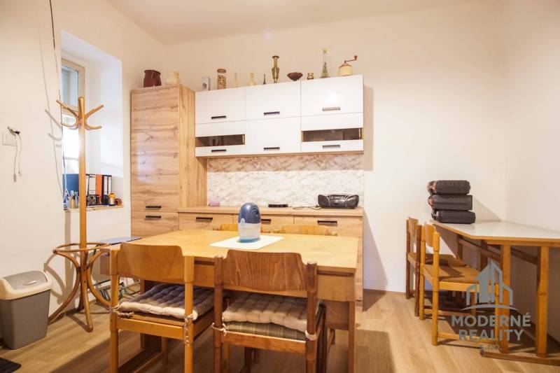 A dining room with wooden furniture and a floor with a wooden design in a family house.