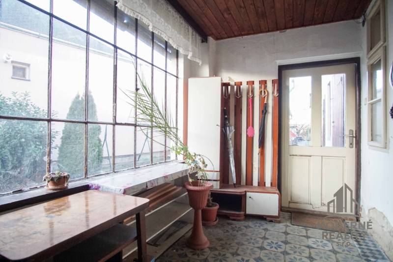 Interior in a family house with a flower pot, table, and umbrella stand.