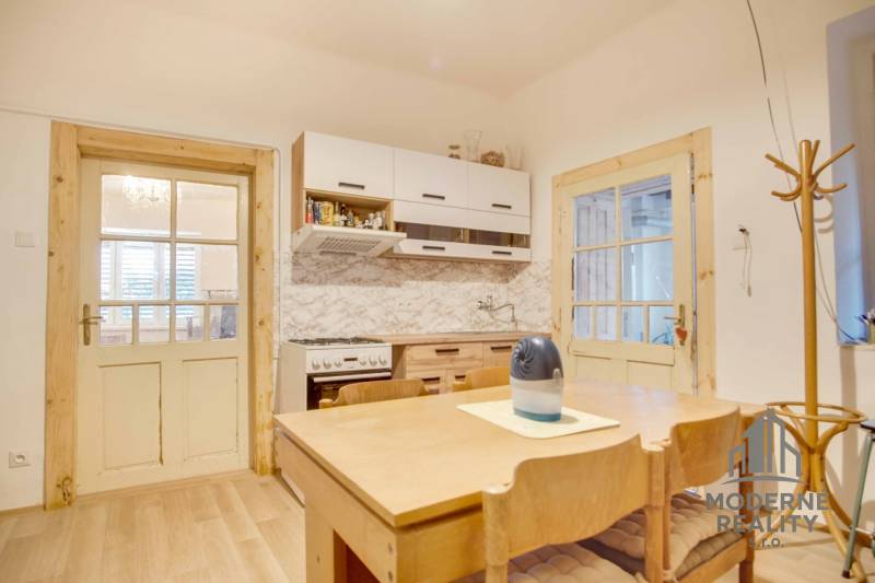 A kitchen in a family house with wooden furniture and a floor with a wooden decor.