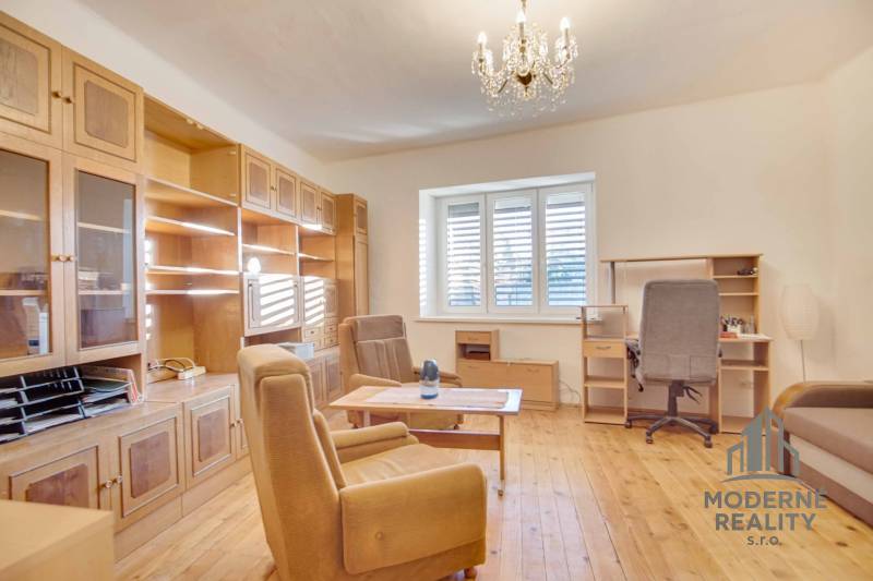 Living room with wooden furniture, wood-patterned floor, chandelier.