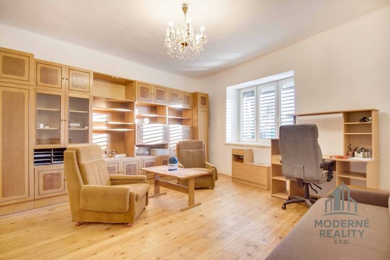 Interior of a family house with furniture, wood-patterned flooring, and a chandelier.