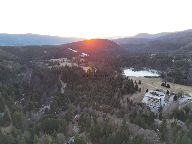 Sunset in Krpáčovo over the forests, lake, and buildings on Krpáčovo street.
