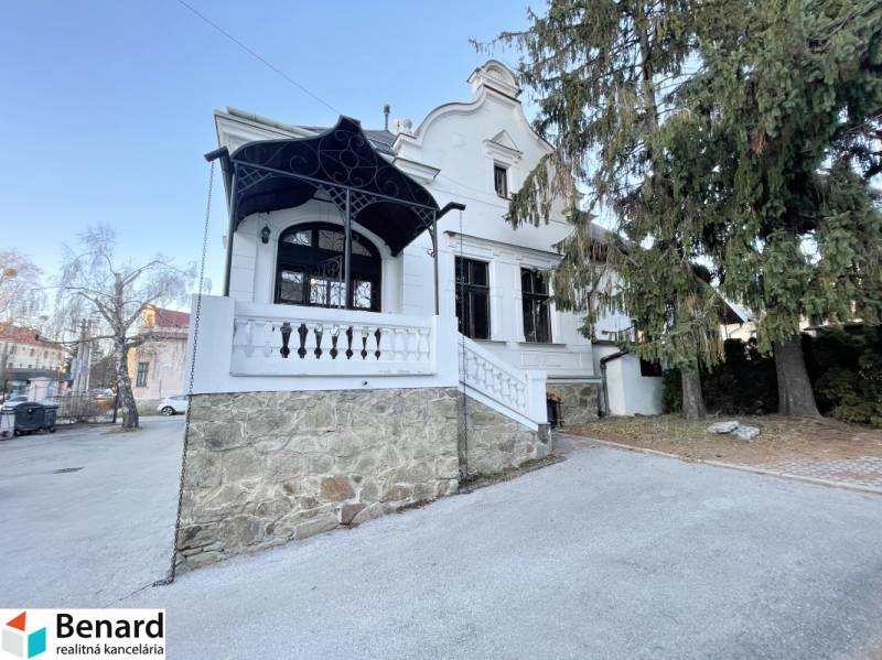 The building on Vajanského Street in Prešov with a stone terrace and trees.