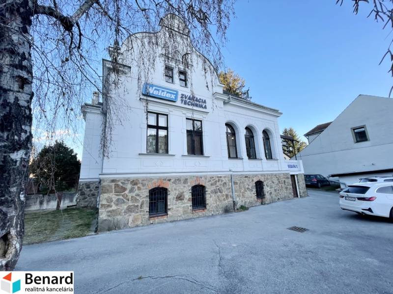 The building on Vajanského Street in Prešov with a stone ground floor and a white facade.