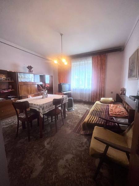Interior of a family house with a dining table, sofa, and television.